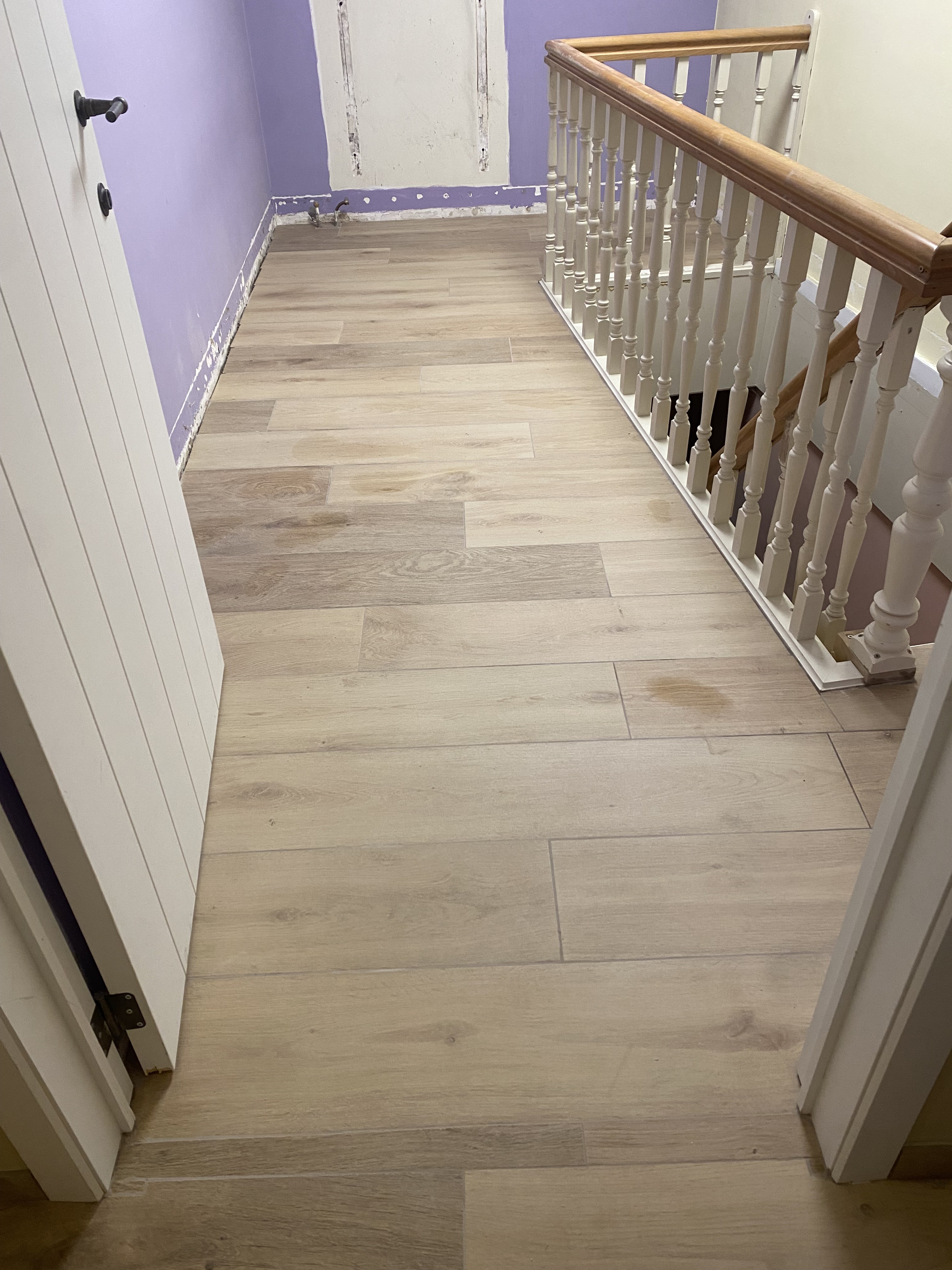 Afgewerkte vloer met houtlook tegels als eindresultaat van de vloeropbouw