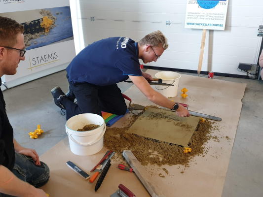 Staenis demo in Sack Zelfbouw Roeselare, Staenisrooster invullen met zandcement