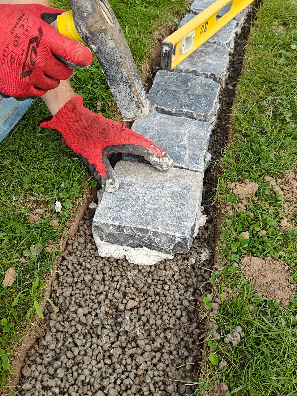 Ajuster la hauteur d’un pavé avec un maillet en caoutchouc